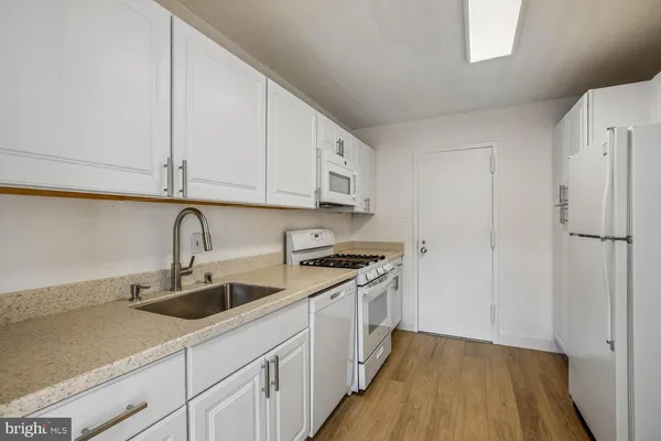 a kitchen with granite countertop white cabinets and a stove