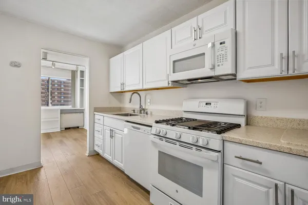 a white refrigerator freezer and a wooden floor in a room