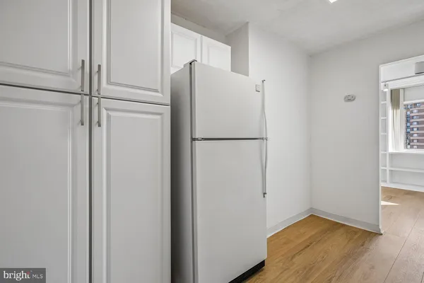 a view of an empty room with wooden floor and a sink