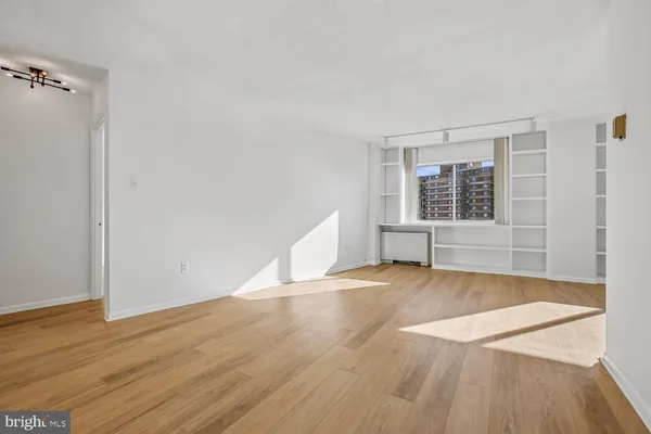 a view of empty room with wooden floor