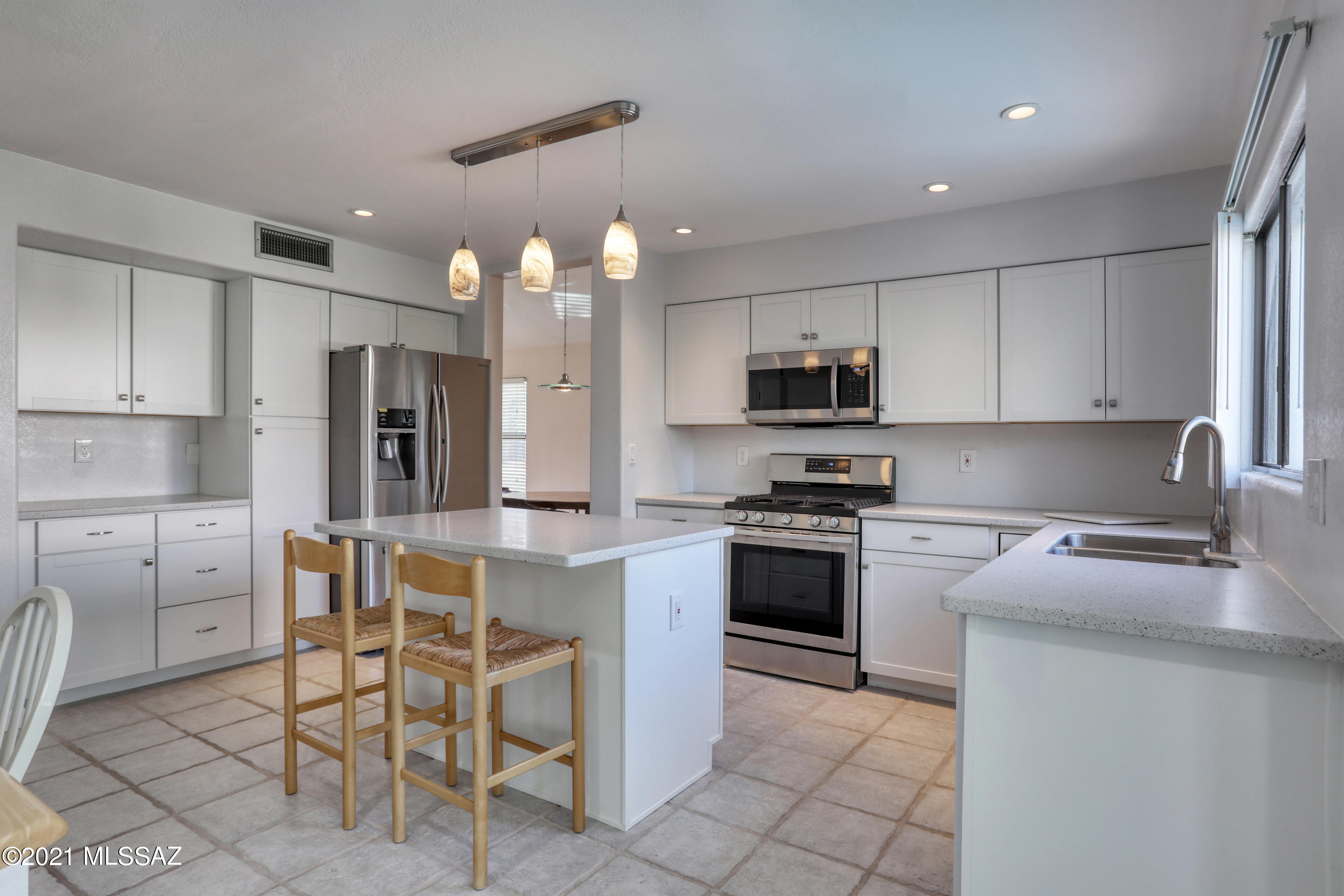 12560 North Wayfarer Way Oro Valley, AZ 85755 - Photo 7 of 43 a kitchen with a sink a microwave and refrigerator