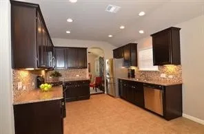 a kitchen with stainless steel appliances granite countertop a sink and a refrigerator