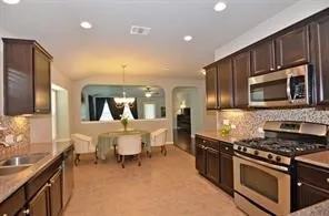 a kitchen with stainless steel appliances a stove a sink a microwave a refrigerator and cabinets