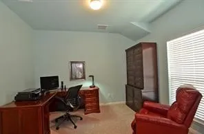 a view of a workspace with furniture and a window