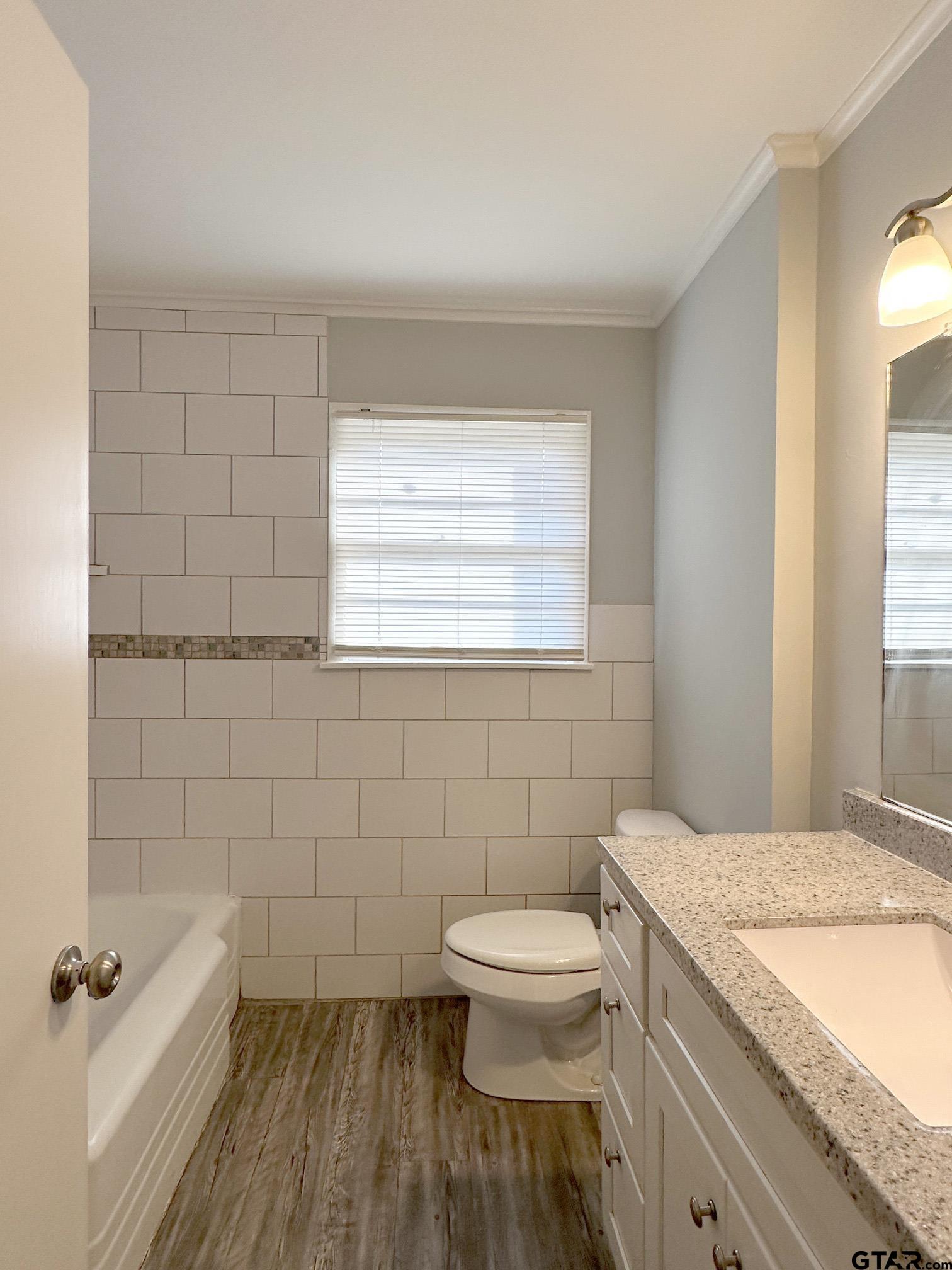 2331 Lingner Drive Tyler, TX 75701 - Photo 8 of 17 a bathroom with a granite countertop toilet a sink a mirror and a window