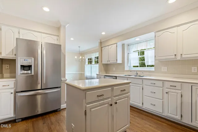 a kitchen with white cabinets and black appliances