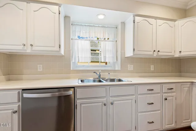 an empty room with wooden floor mirror and windows