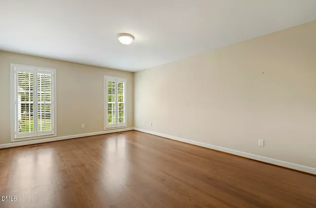 a view of an empty room with wooden floor
