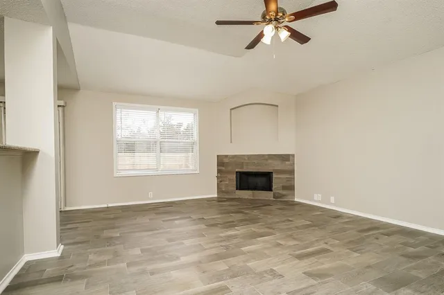 a view of an empty room with a fireplace and a window