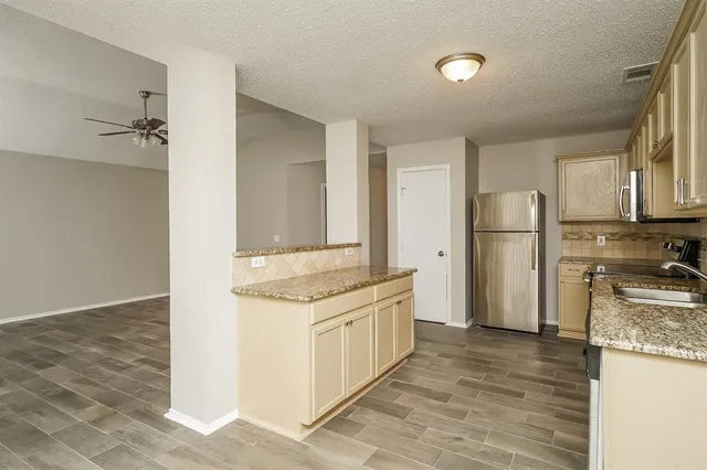 a kitchen with stainless steel appliances granite countertop a refrigerator and a stove