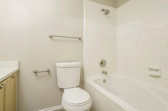 a white toilet sitting next to a bath tub