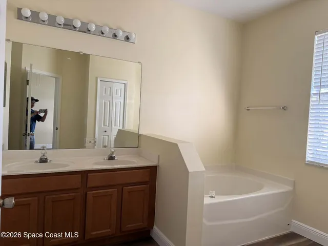 a bathroom with a tub sink and mirror