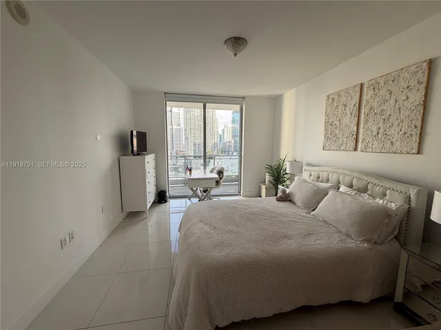 a spacious bedroom with a bed and glass windows