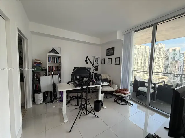 a view of a livingroom with workspace and a window