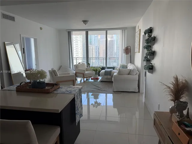 a living room with furniture and large windows