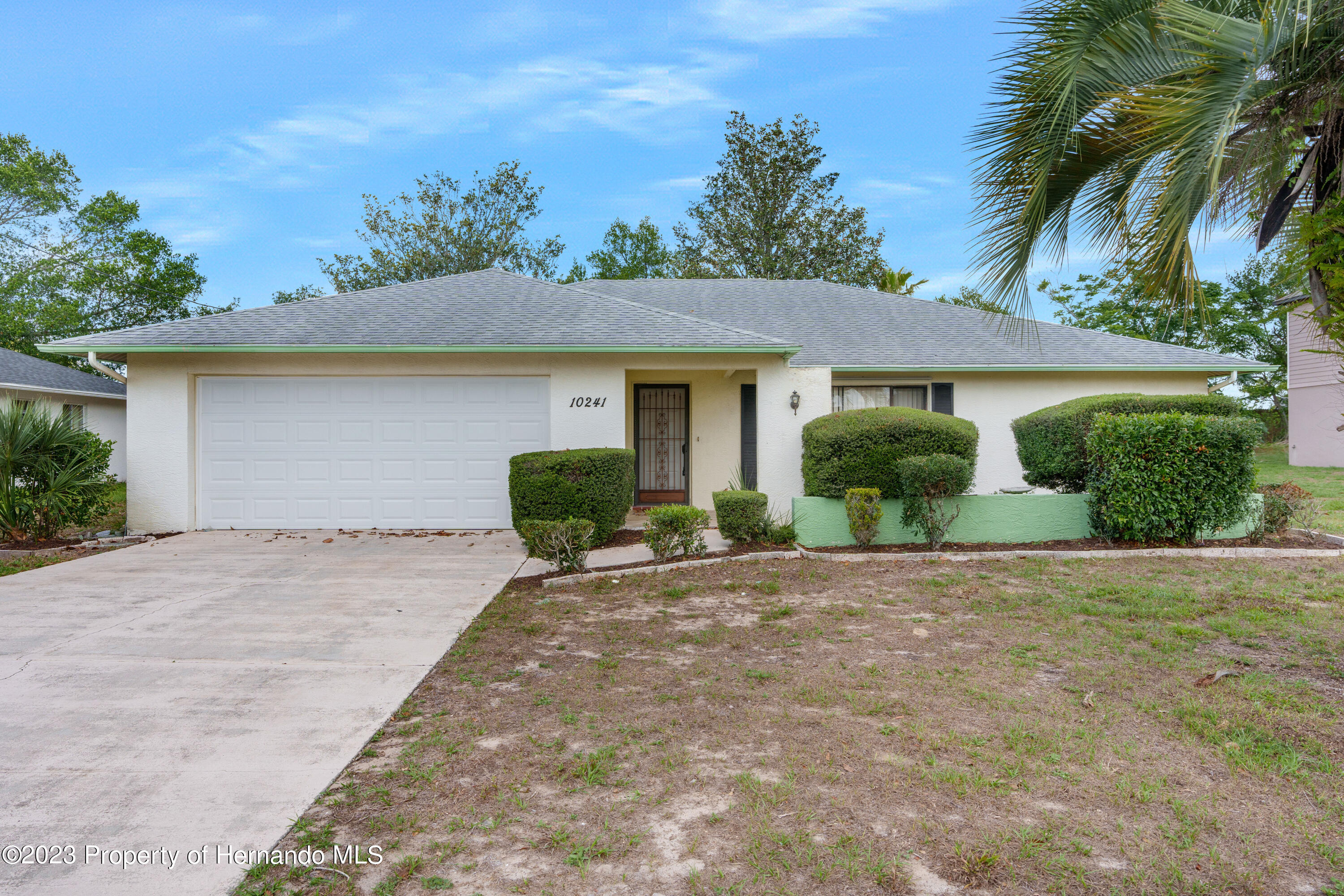 10241 Bedford Road Spring Hill, FL 34608 - Photo 30 of 32 a view of a house with a yard and potted plants
