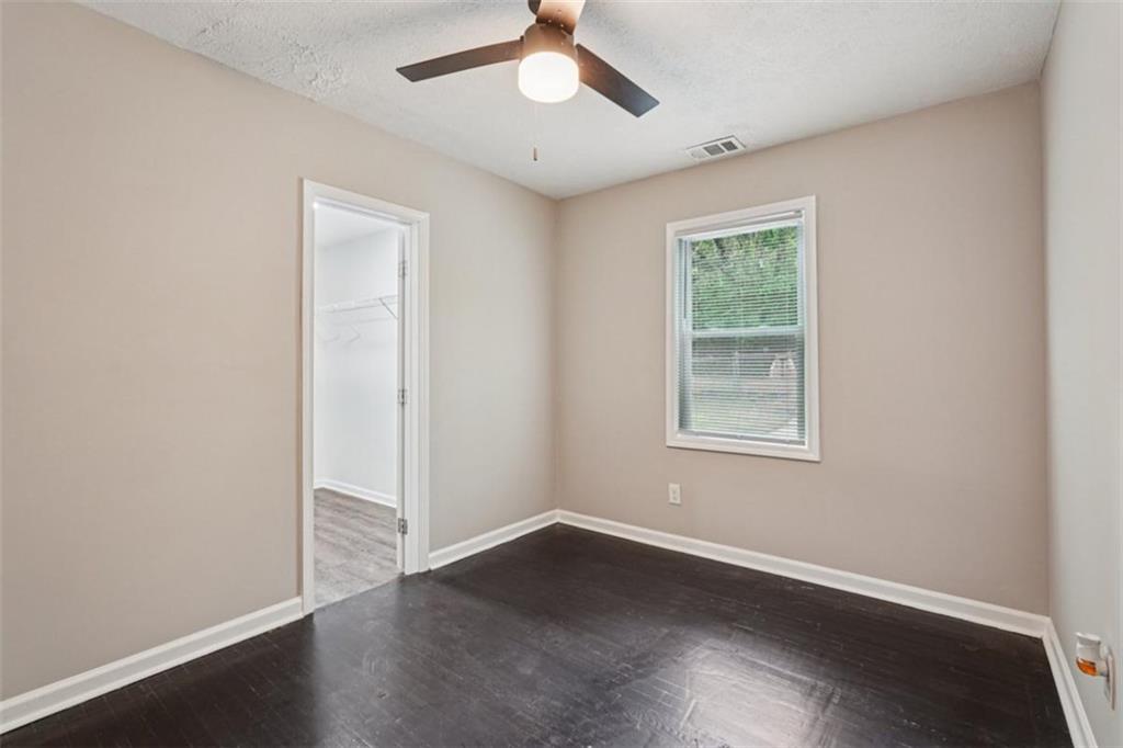 172 Meador Way Southeast Atlanta, GA 30315 - Photo 12 of 34 an empty room with wooden floor chandelier fan and windows