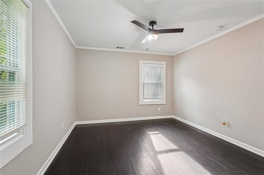 172 Meador Way Southeast Atlanta, GA 30315 - Photo 19 of 34 an empty room with wooden floor fan and windows