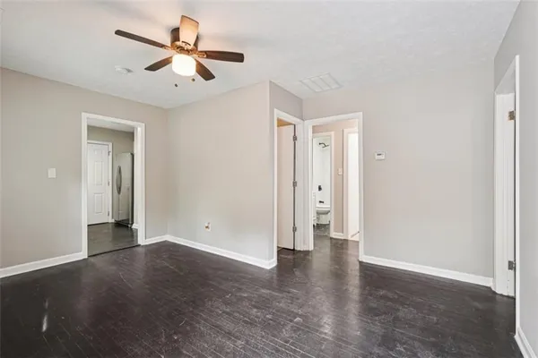 an empty room with closet and a ceiling fan
