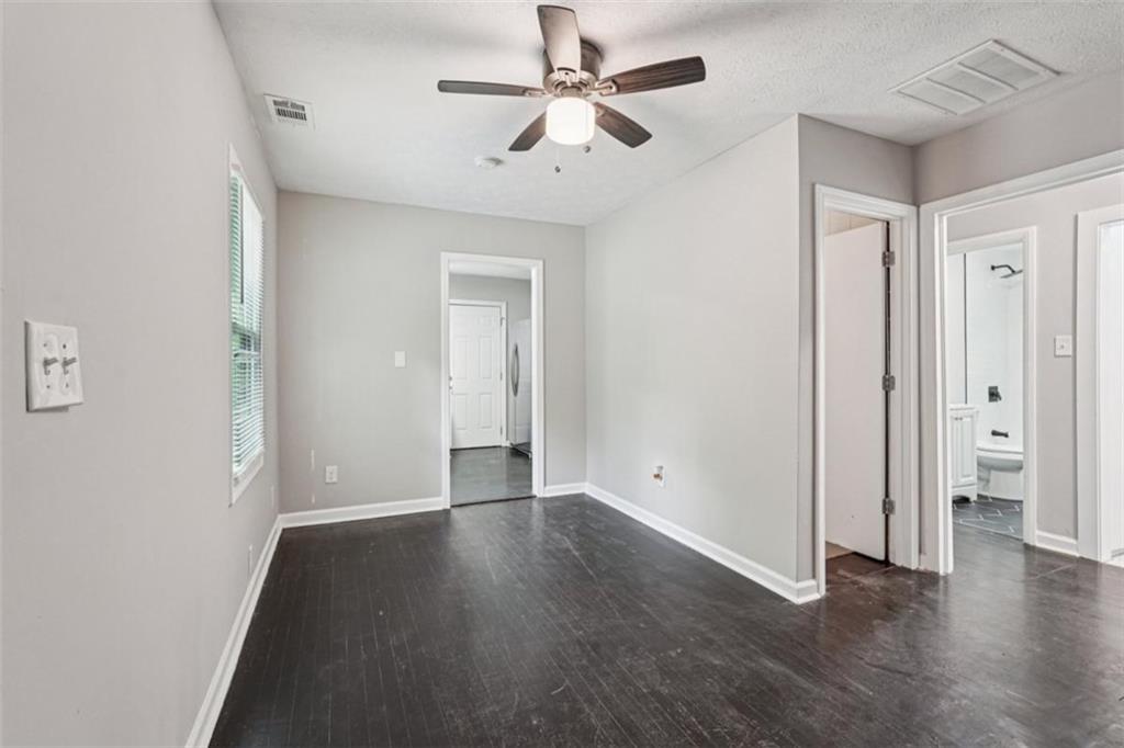 172 Meador Way Southeast Atlanta, GA 30315 - Photo 5 of 34 an empty room with wooden floor and ceiling fan