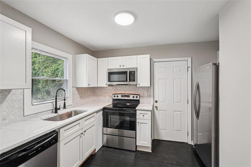 172 Meador Way Southeast Atlanta, GA 30315 - Photo 8 of 34 a kitchen with white cabinets and appliances