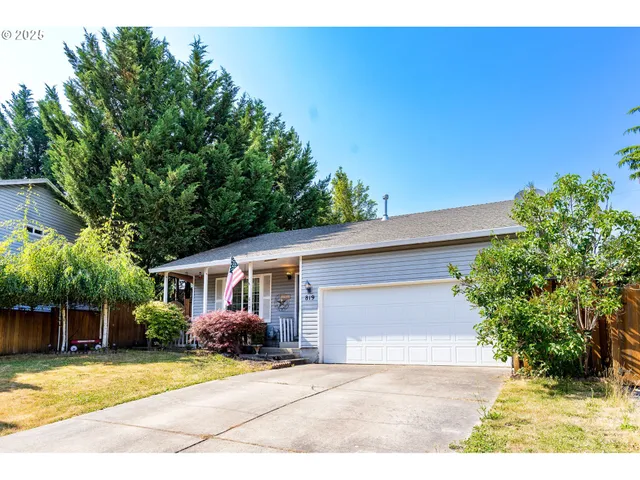 a front view of a house with a yard and potted plants