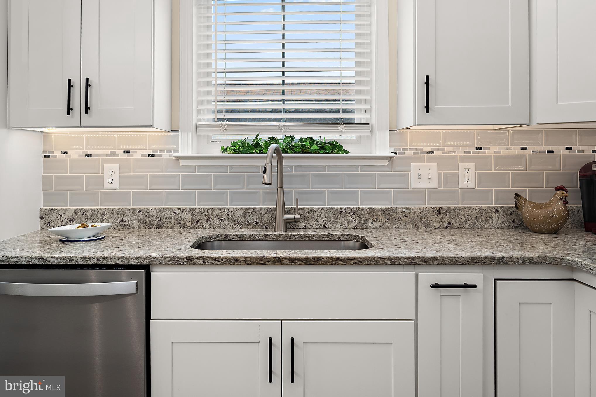 144 Clamshell Road Ocean City, MD 21842 - Photo 17 of 64 a kitchen with granite countertop white cabinets and a sink