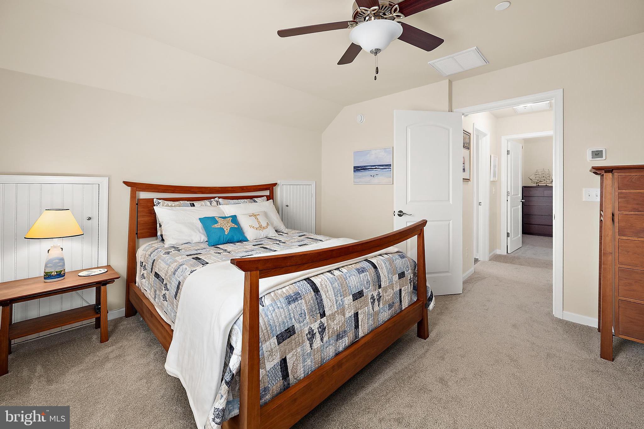 144 Clamshell Road Ocean City, MD 21842 - Photo 37 of 64 a bedroom with a bed and a chandelier