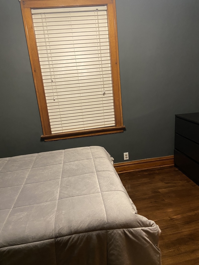 4818 South Springfield Avenue Chicago, IL 60632 - Photo 5 of 36 a bed sitting in a bedroom next to a window