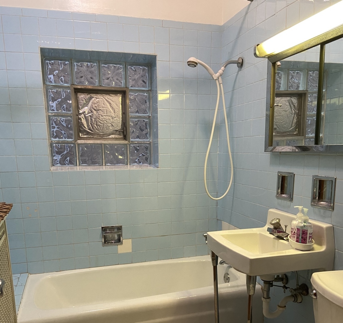 4818 South Springfield Avenue Chicago, IL 60632 - Photo 6 of 36 a bathroom with a sink mirror and a bath tub