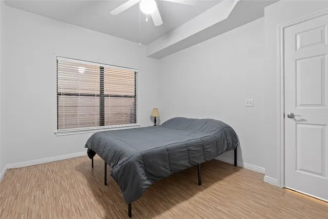 a bedroom with a bed wooden floor and window