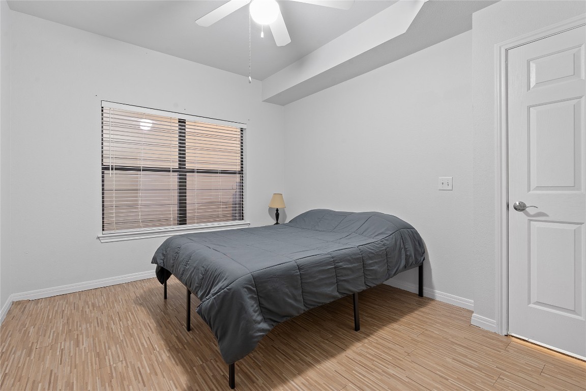 2515 Pearl Street, Unit 410 Austin, TX 78705 - Photo 11 of 11 a bedroom with a bed wooden floor and window