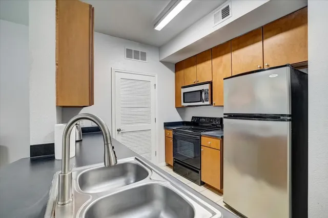 a kitchen with granite countertop a refrigerator and a sink