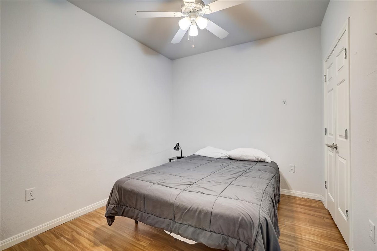 2515 Pearl Street, Unit 206 Austin, TX 78705 - Photo 4 of 11 Bedroom featuring light wood-style flooring and a ceiling fan