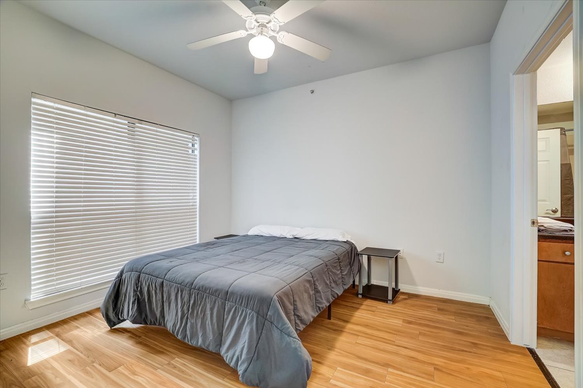 2515 Pearl Street, Unit 206 Austin, TX 78705 - Photo 7 of 11 Bedroom featuring light wood-style floors and a ceiling fan