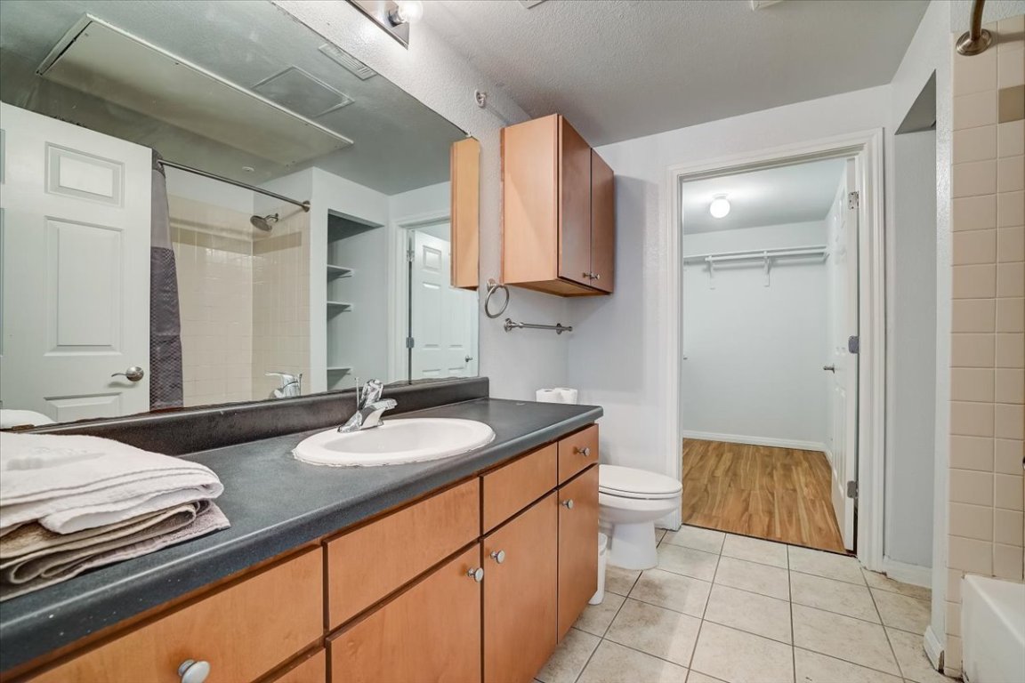 2515 Pearl Street, Unit 410 Austin, TX 78705 - Photo 8 of 11 a bathroom with a granite countertop sink and a mirror