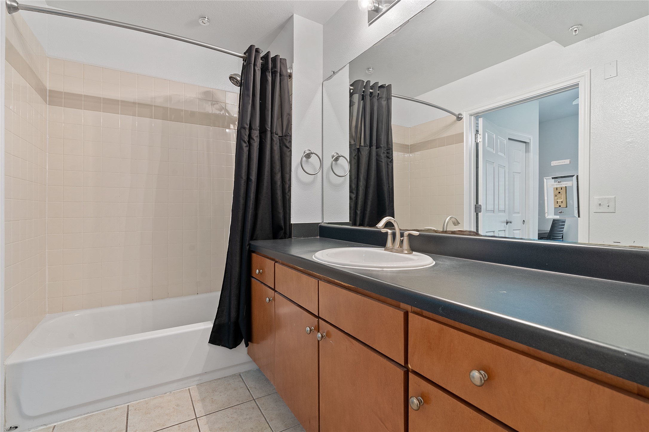 2515 Pearl Street, Unit 206 Austin, TX 78705 - Photo 10 of 11 Bathroom featuring light tile patterned floors, shower / bathtub combination with curtain, and vanity