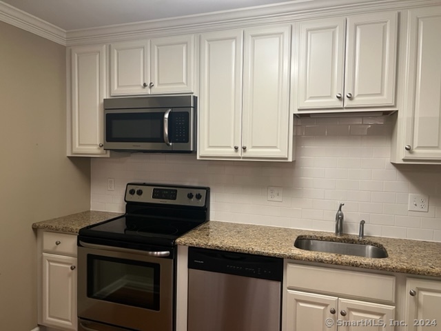 67 West Main Street, Unit 122 Clinton, CT 06413 - Photo 6 of 14 a kitchen with granite countertop white cabinets and a stove top oven