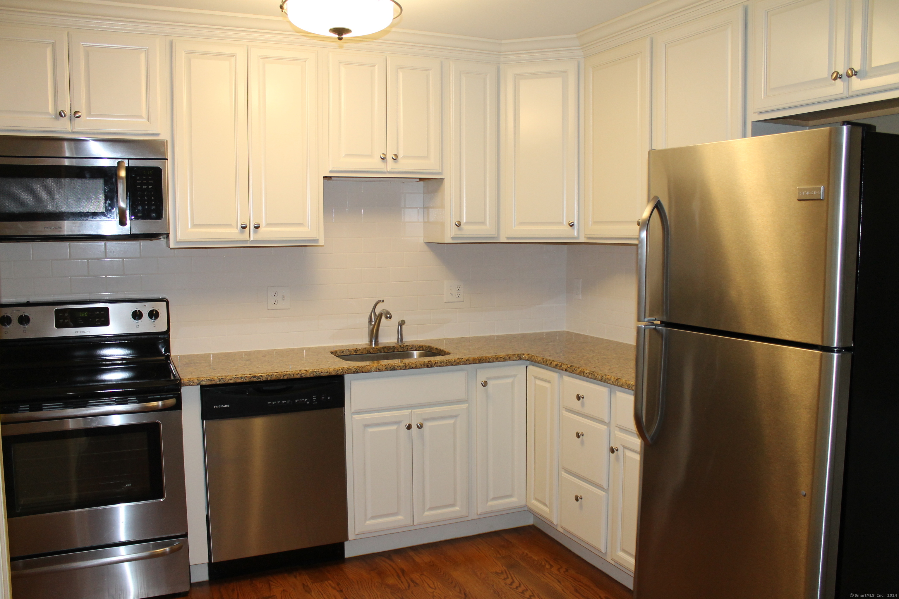 67 West Main Street, Unit 122 Clinton, CT 06413 - Photo 7 of 14 a kitchen with stainless steel appliances a refrigerator sink and cabinets
