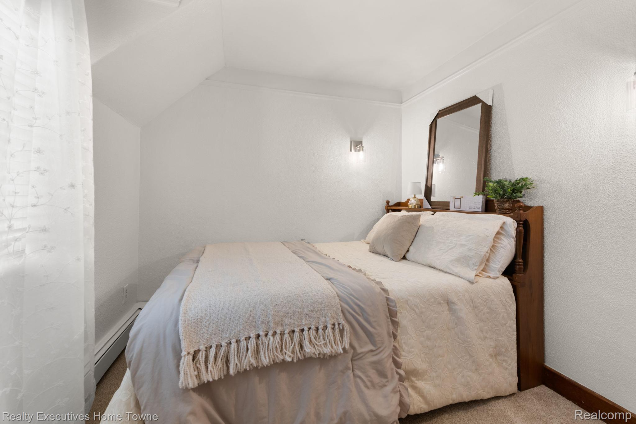 8308 Lakeshore Road Fort Gratiot, MI 48059 - Photo 54 of 79 Bedroom featuring neutral-toned walls, wall-mounted sconce lighting, and sloped ceiling details
