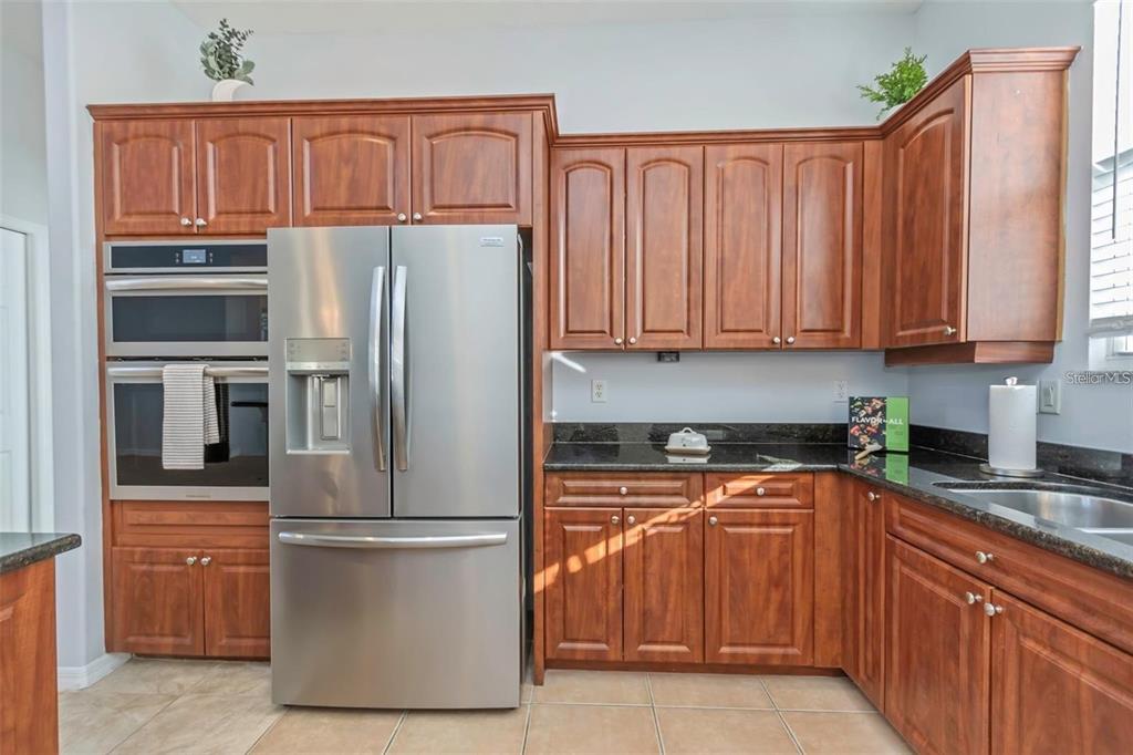 7327 Brightwaters Court New Port Richey, FL 34652 - Photo 11 of 45 a kitchen with stainless steel appliances granite countertop a refrigerator sink and cabinets