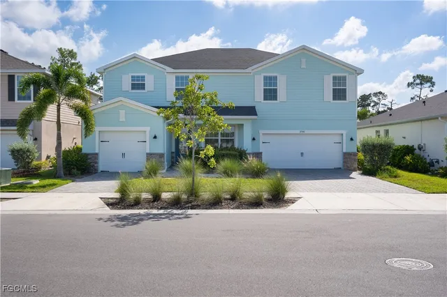 front view of house with a yard and potted plants