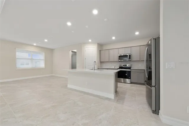 a open kitchen with white cabinets and stainless steel appliances