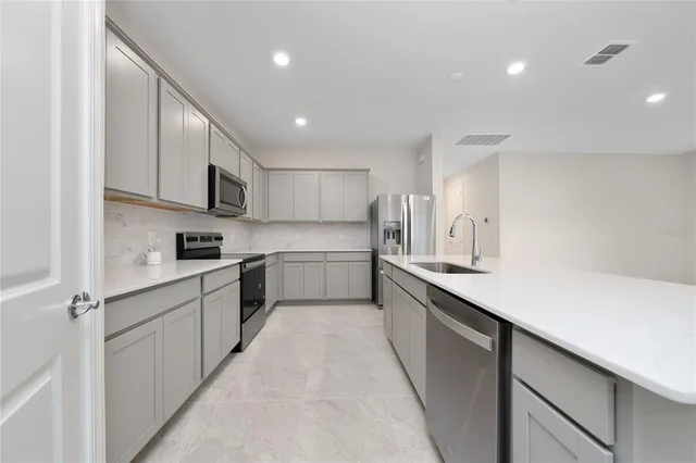 a kitchen with stainless steel appliances sink refrigerator and microwave