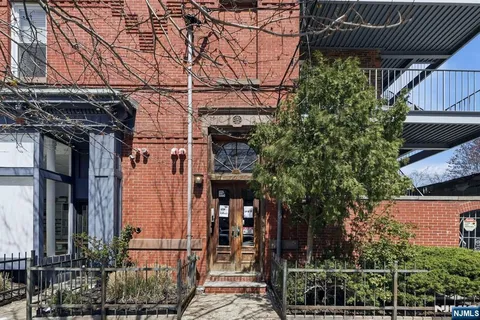 a view of a house with a tree and wooden fence