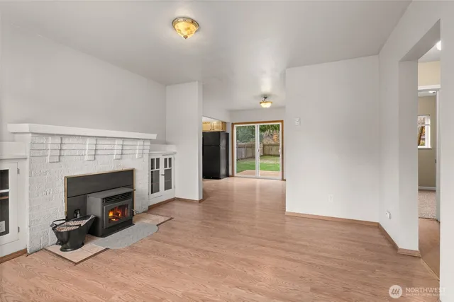 an empty room with windows and fireplace