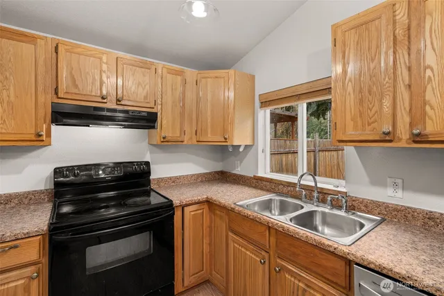 a kitchen with a sink a refrigerator and cabinets