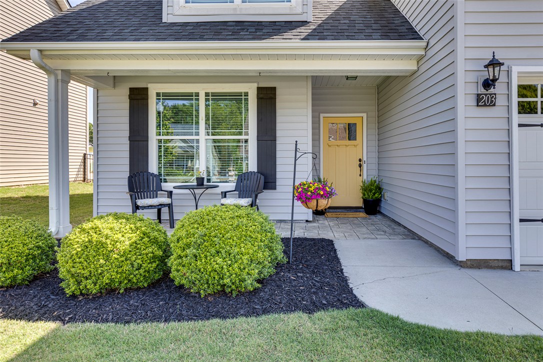203 Streams Way Anderson, SC 29625 - Photo 3 of 47 This charming home offers a welcoming facade with a bright yellow door and meticulously maintained landscaping.