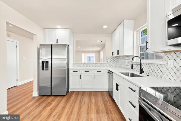 a kitchen with granite countertop a sink stainless steel appliances and cabinets