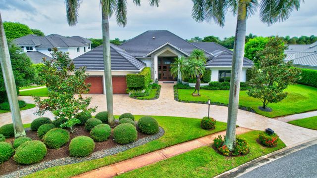 a view of house with garden and tall tress